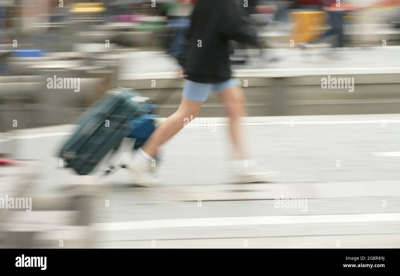 Voyageur marchant avec sac de voyage, valise à roulettes. Banque D'Images