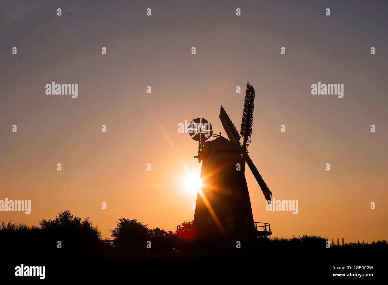 Thaxted, Essex, Royaume-Uni. 5 août 2021. Le soleil se lève au-dessus du moulin à vent de John Webb, qui est un moulin à tour classé de catégorie II à Thaxted, Essex . Crédit : Jason Mitchell/Alay Live News. Banque D'Images