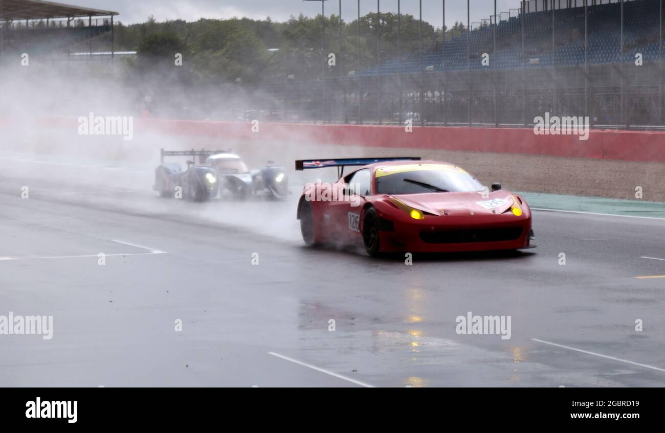 Une Ferrari 458 GT3 et une Peugeot 90X, qualifiant sous la pluie, pour la course Masters Endurance Legends, au Silverstone Classic 2021 Banque D'Images