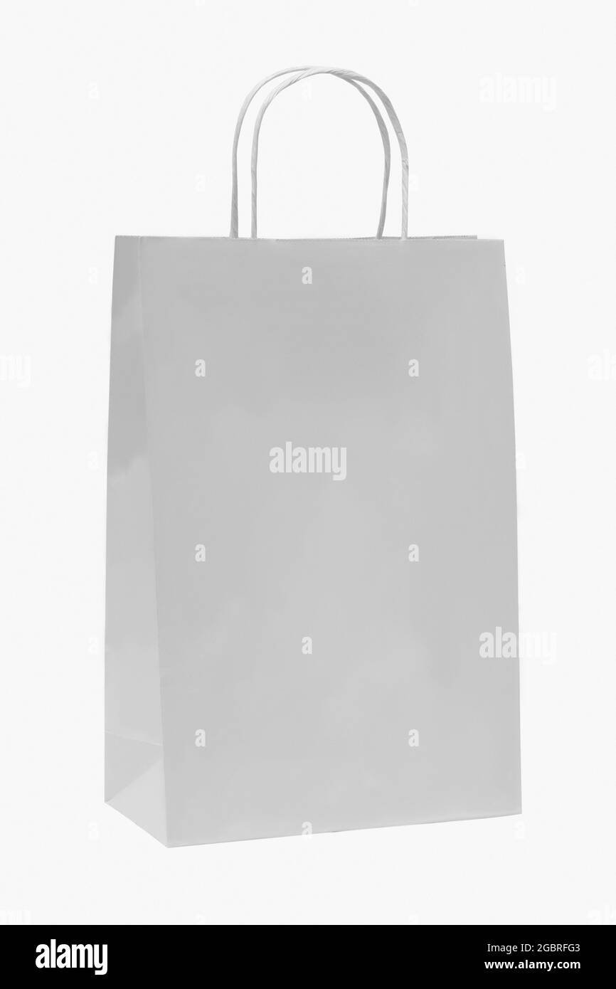 Sac de papier blanc sur fond blanc. Maquette pour le design. Concept publicitaire. Verticale. Banque D'Images
