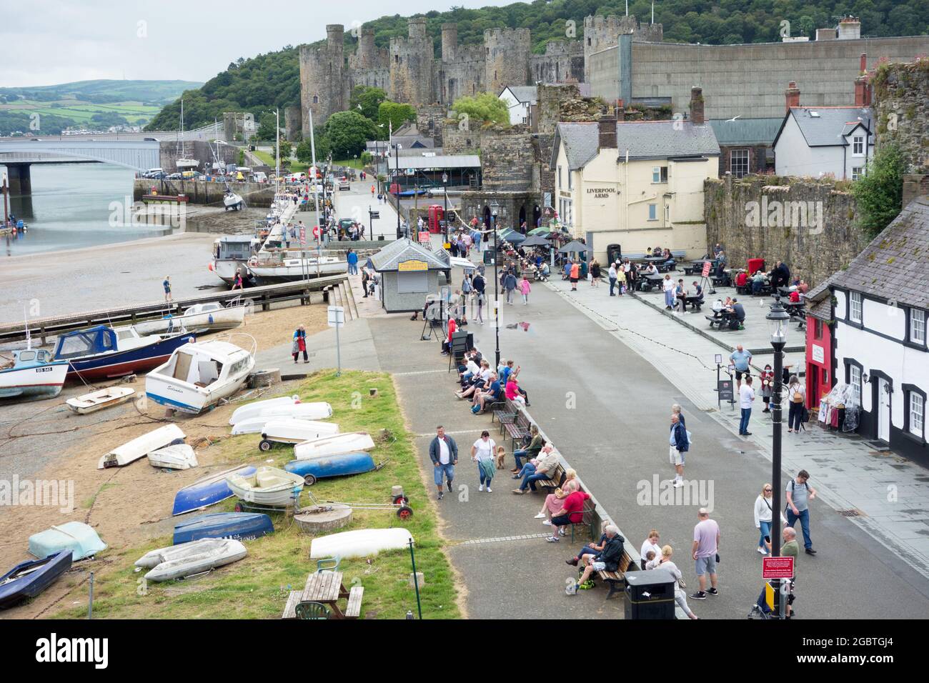 Conwy port dans le nord du pays de Galles plein de touristes avec le château en arrière-plan Banque D'Images
