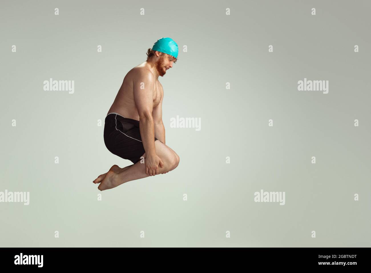 Plongee Amusante Adorable Homme A Tete Rouge Dans Un Short De Natation Rouge Pose Isole Sur Fond Gris Studio Concept De Sport D Humour Et De Corps Positif Photo Stock Alamy