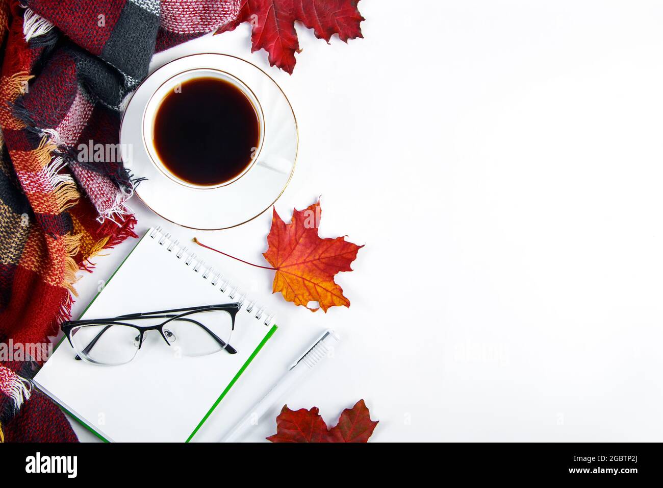 Concept Hello Autumn. Tasse de café expresso chaud et feuilles rouges tombées sur fond blanc. Un écossais chaud et une boisson chaude par temps froid. Copier l'espace. Banque D'Images