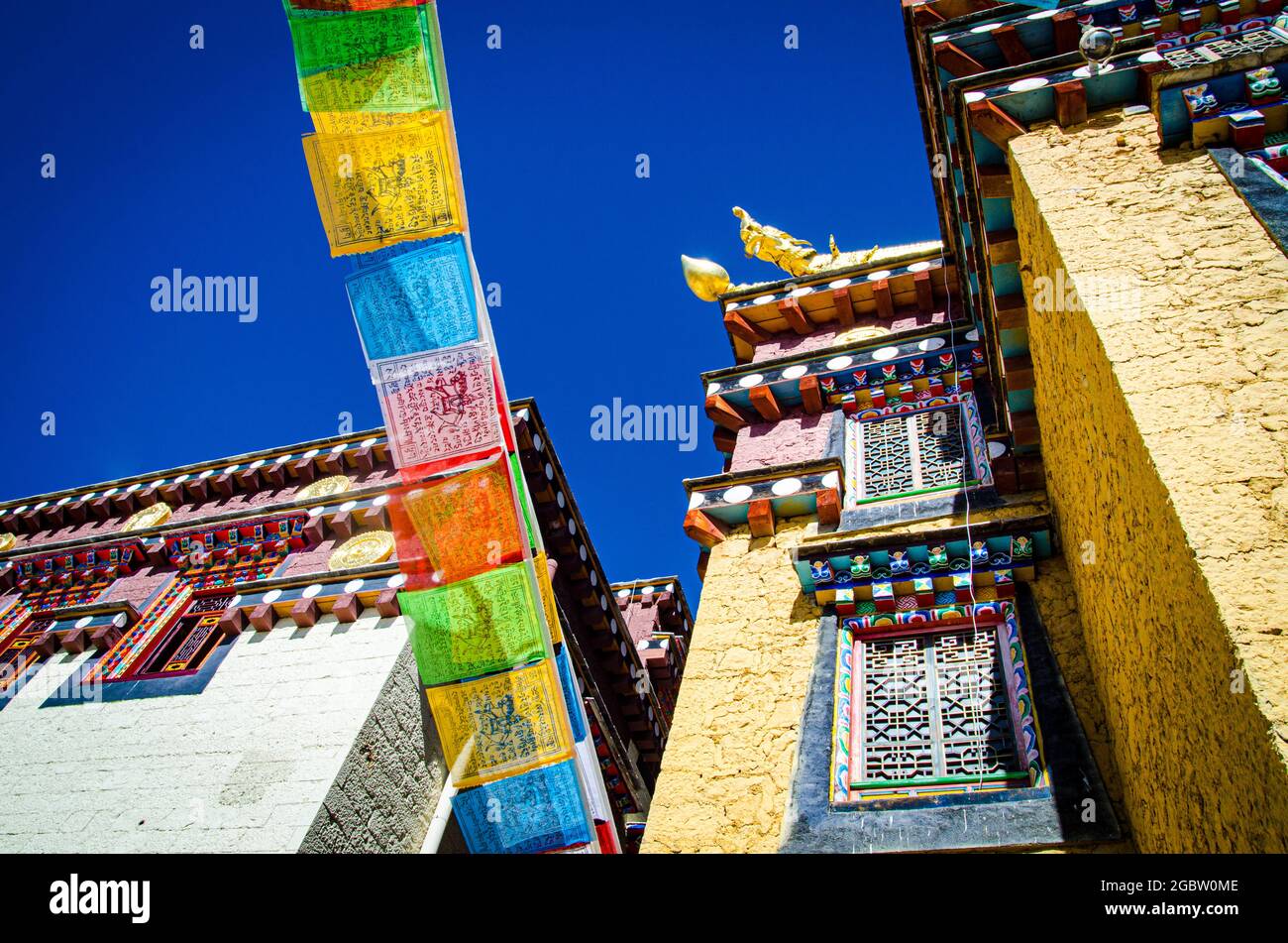 Drapeaux de prière tibétains colorés qui diffusent de la chance et des bénédictions accrochées au mur du monastère. Banque D'Images