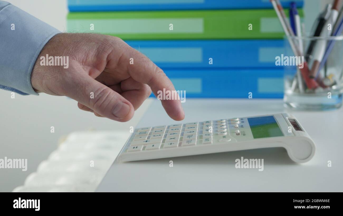 Homme d'affaires travaillant avec des factures, effectue des calculs financiers avec Adding machine. Calcul des frais comptables et des taxes. Banque D'Images