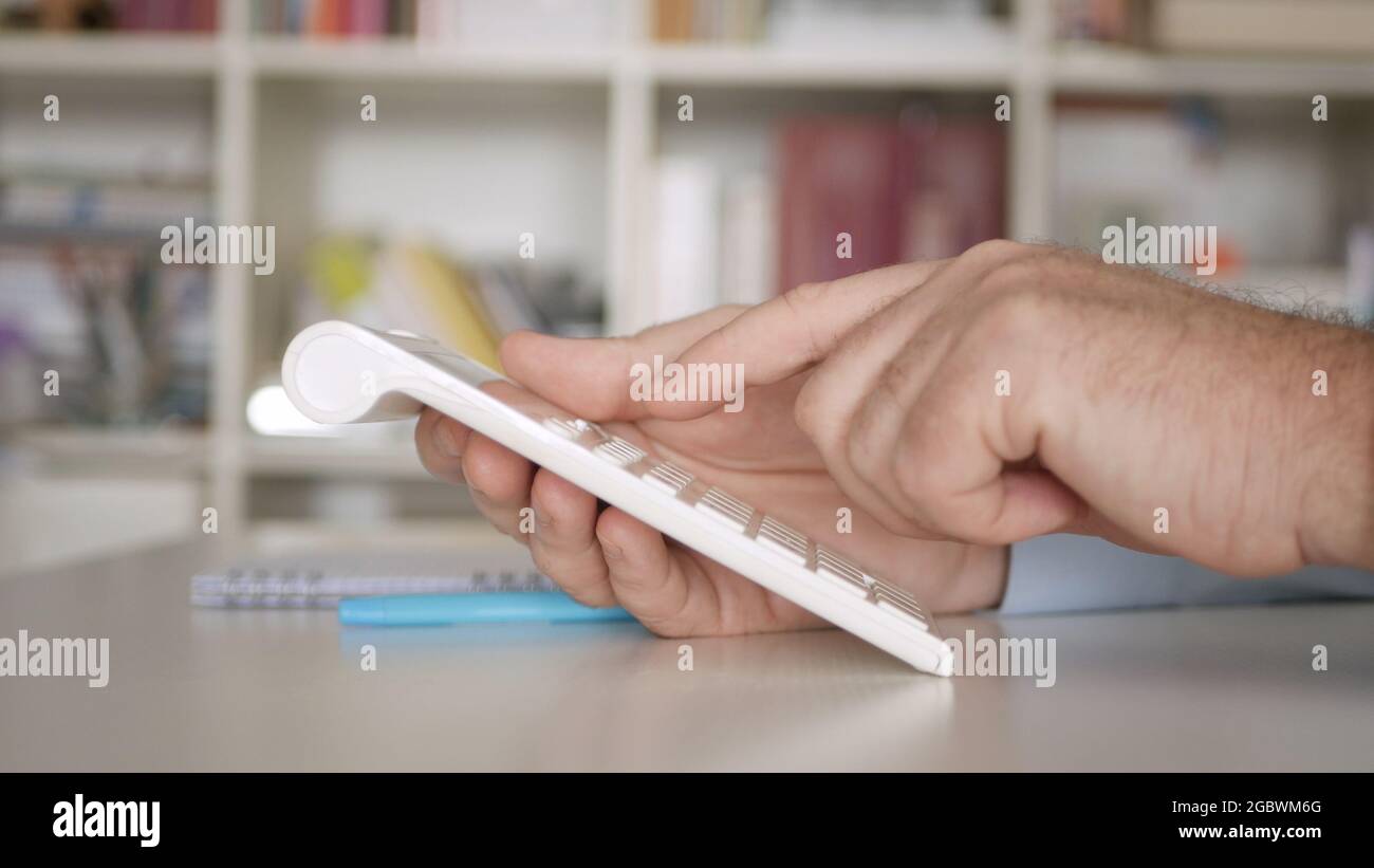 Homme d'affaires travaillant avec des factures, effectue des calculs financiers avec Adding machine. Calcul des frais comptables et des taxes. Banque D'Images