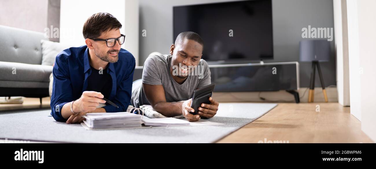 Un couple gay heureux fait des impôts et de la planification du revenu avec le calculateur Banque D'Images