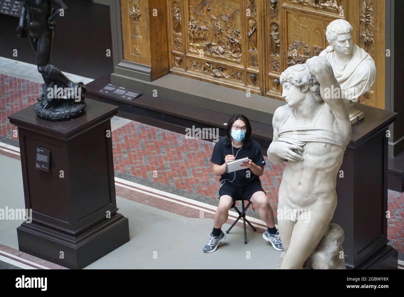 Londres, Royaume-Uni, 5 août 2021 : un artiste s'esquisse sur les terrains de casting du Victoria & Albert Museum, avec des reproductions en plâtre de célèbres monuments et sculptures. La plupart des visiteurs portent des masques faciaux et font un certain effort pour rester socialement distancé les uns des autres. Avec une nette réduction du nombre de personnes aidées par l'application NHS Covid la semaine dernière, les destinations touristiques basées au Royaume-Uni pourraient bénéficier des changements confus dans les règles affectant le tourisme international. Anna Watson/Alay Live News Banque D'Images