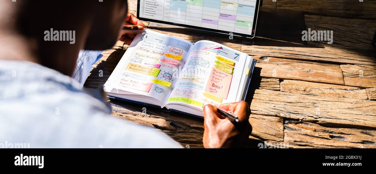 Organisation de l'ordre du jour et de l'horaire de la réunion. Afro-américain utilisant Planner Banque D'Images
