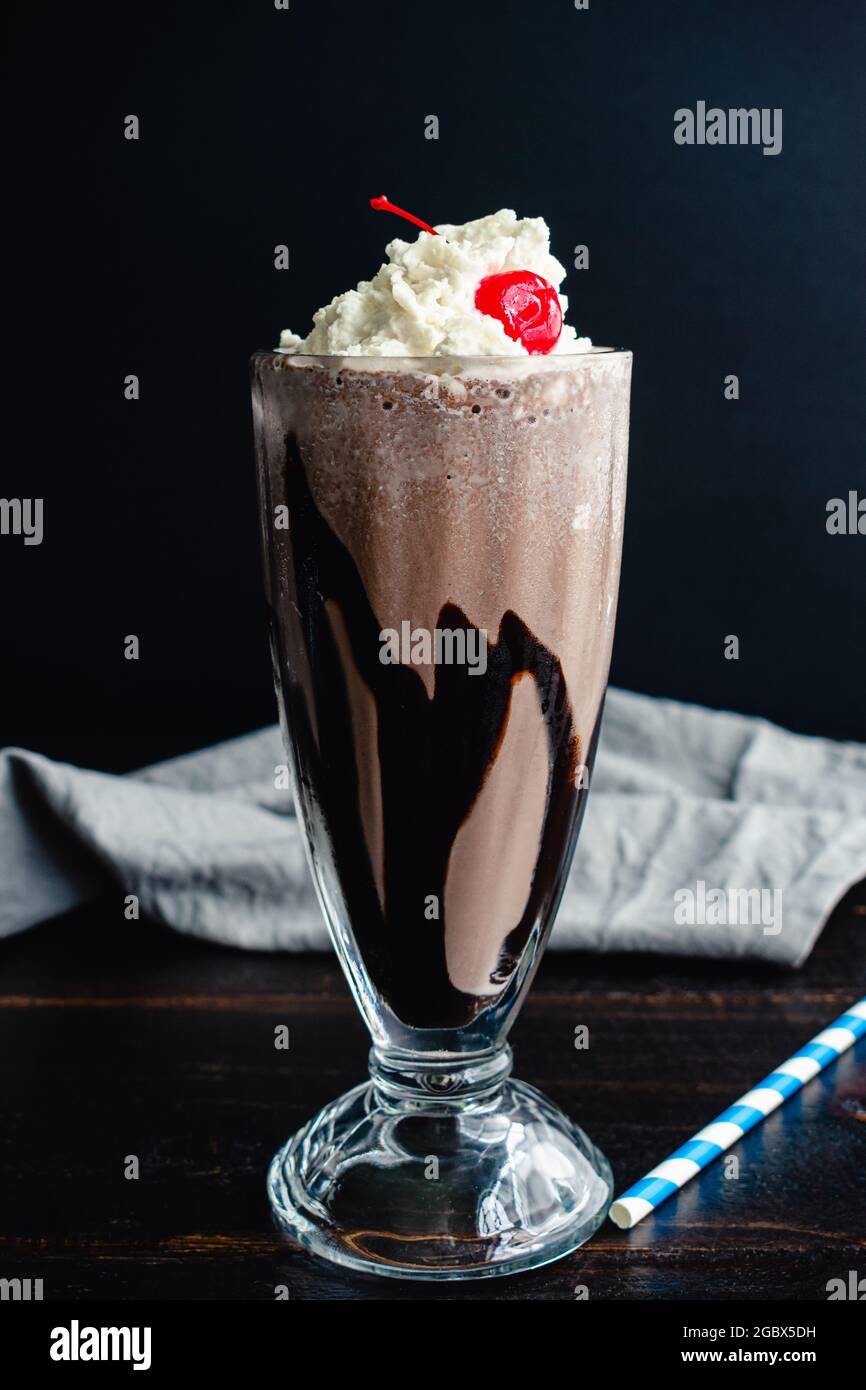 Milk-Shake au chocolat Bourbon avec une cerise sur le dessus : Milk-Shake au chocolat noir avec whisky bourbon et garniture à la crème fouettée Banque D'Images