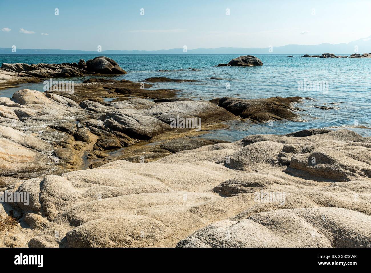 Vue sur la mer de la plage rocheuse avec de belles formations rocheuses.  Les vagues de la mer sécraseront et éclaboussement sur les rochers. Vue  sur la mer et locéan. Fond bleu