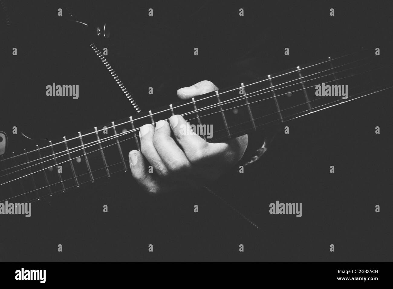 guitariste qui plie la corde tout en jouant un solo en noir et blanc Banque D'Images