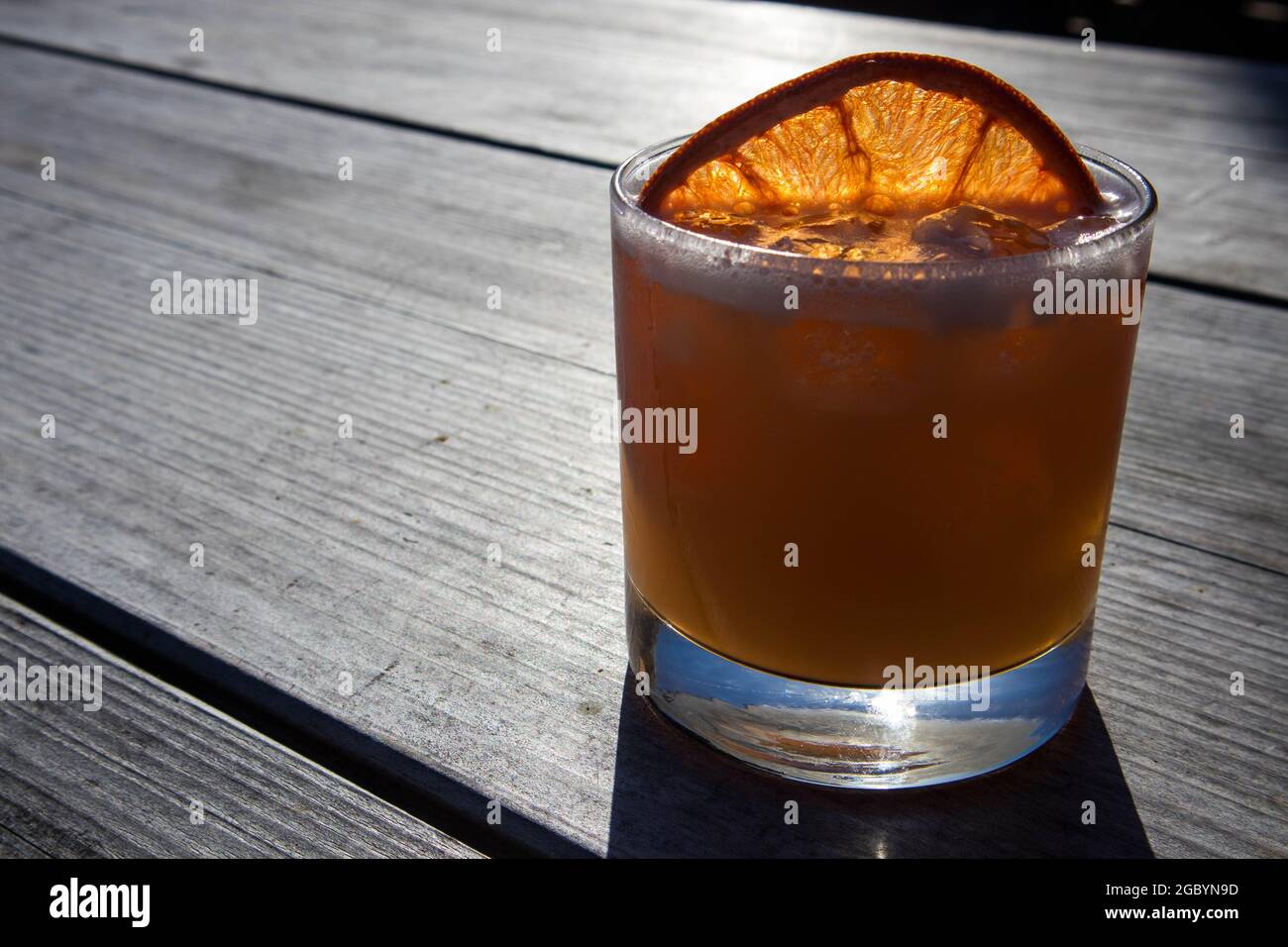 Un cocktail Whisky à l'orange est servi dans un bar extérieur sur une table en bois à Bodega Bay, Californie Banque D'Images