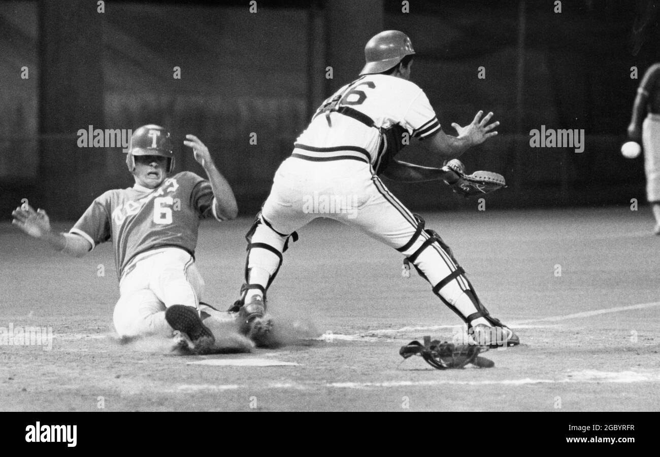 Austin Texas USA, vers 1982 : action entre l'équipe de baseball masculine de l'Université du Texas et les adversaires sur le terrain d'UT ; le receveur attend de lancer comme le précurseur glisse dans la plaque d'origine pour marquer une course. ©Bob Daemmrich Banque D'Images