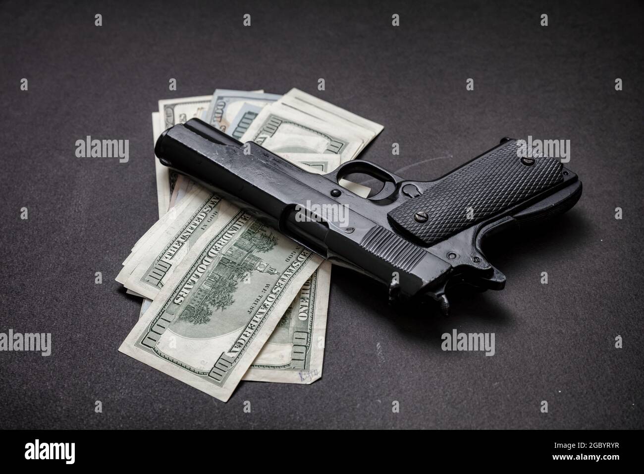 Crime concept, pistolet pistolet 9 mm et billets en dollars américains sur fond noir. L'argent criminel, la mafia et le concept de corruption, Banque D'Images