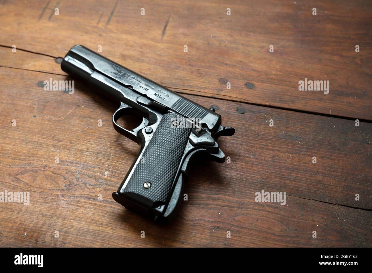 Pistolet 9 mm sur fond en bois. Arme en métal noir, arme de poing automatique pour l'armée et la sécurité sur une table vintage. Vue latérale Banque D'Images