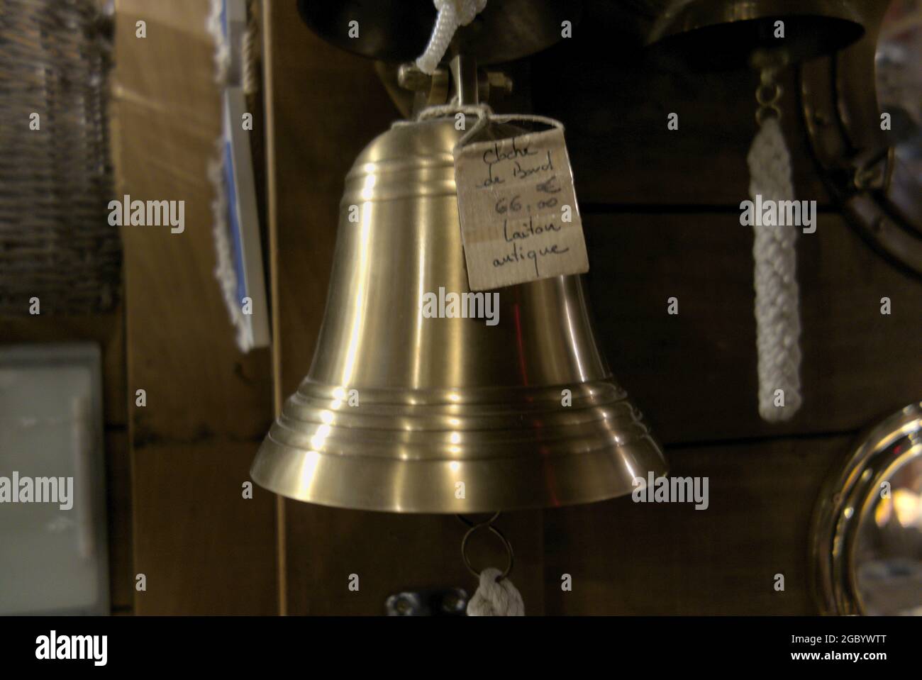 La cloche du bateau brillant dans l'offre d'un revendeur d'occasion et d'un revendeur d'antiquités - avec l'étiquette de prix et l'information de prix Banque D'Images