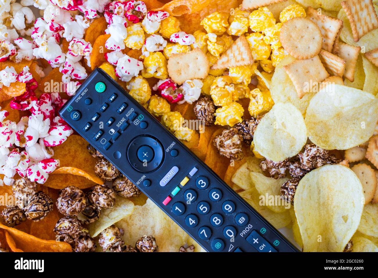 Pop-corn salé et sucré et croustilles sur fond blanc, vue en angle bas Banque D'Images