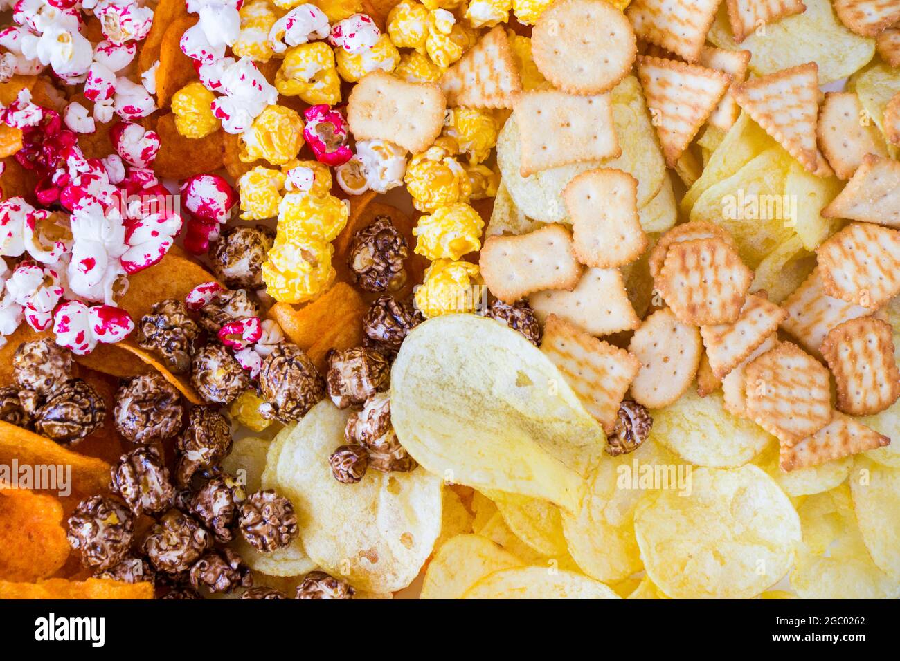 Pop-corn salé et sucré et croustilles sur fond blanc, vue en angle bas Banque D'Images