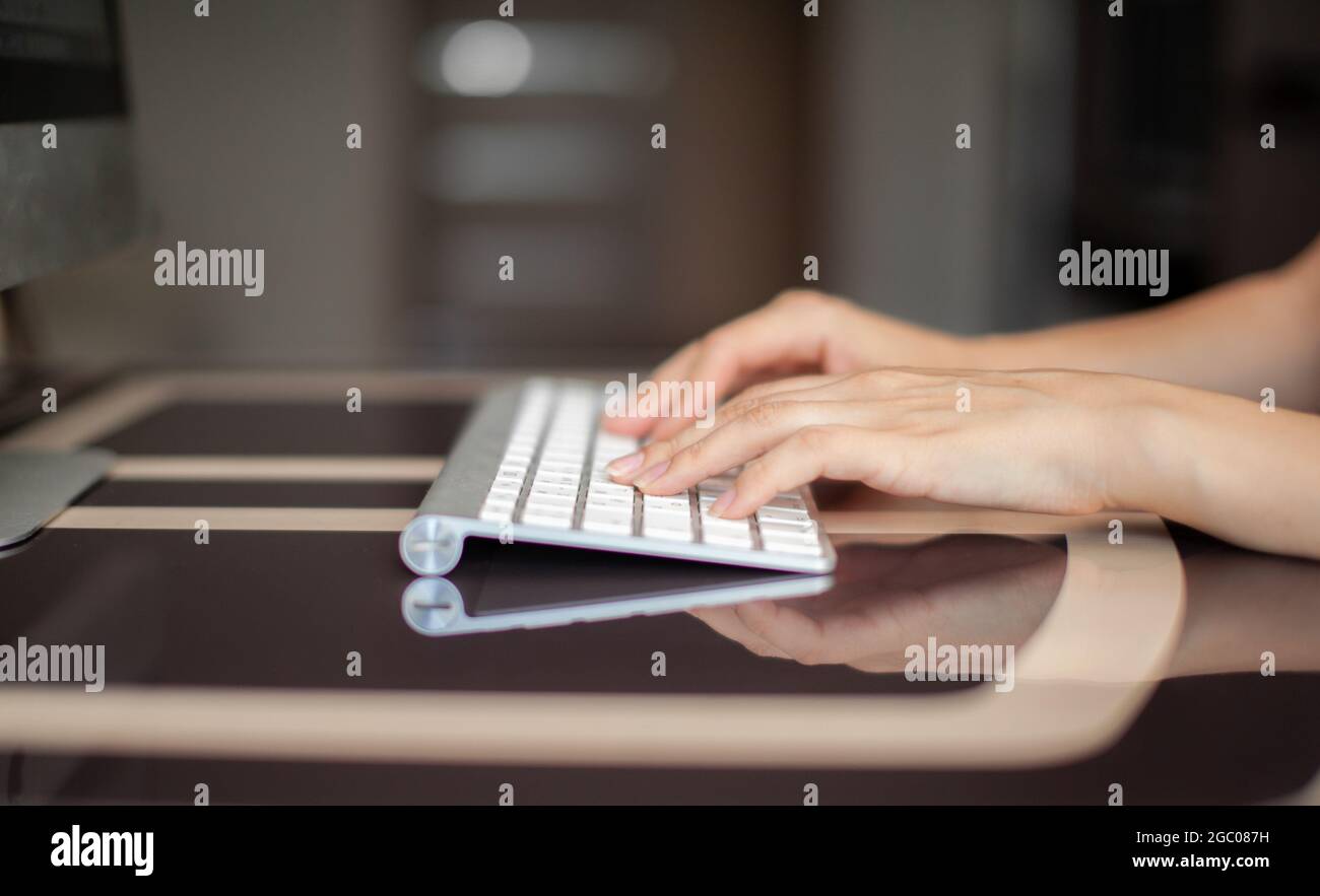 Les femmes tapissent du texte sur le clavier tout en échangeant des messages avec des amis via des réseaux sociaux à l'aide d'un ordinateur portable. Une employée de bureau ch Banque D'Images