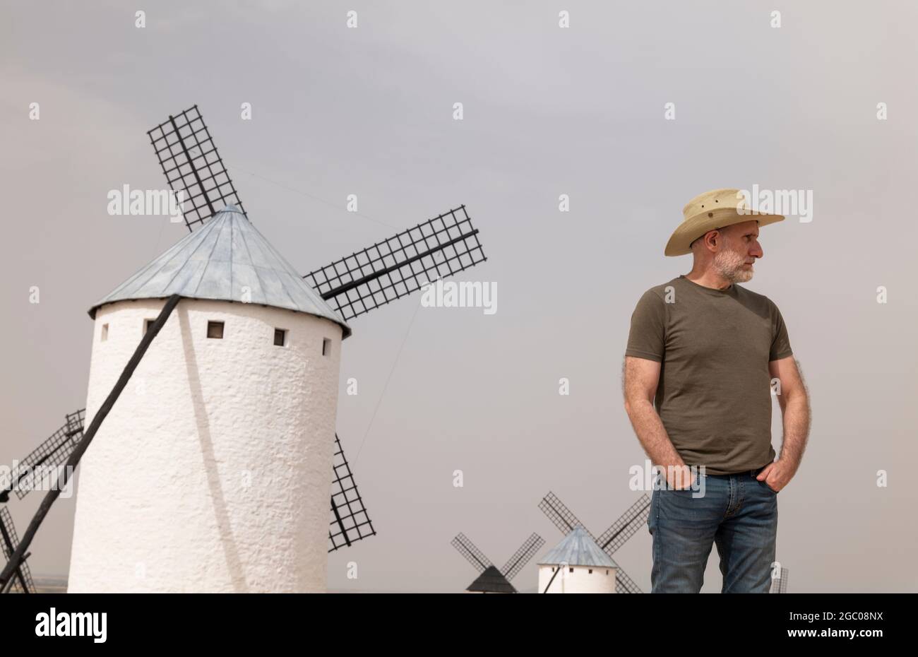 Un homme portant un chapeau de cow-boy avec des moulins à vent dans la  campagne Photo Stock - Alamy