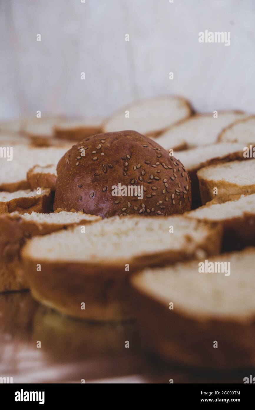 Pain hamburger placé sur une planche à découper. Planche à découper avec des tranches de pain aux graines de sésame pour faire des hamburgers. Sandwichs au sésame pour le méa moulu Banque D'Images