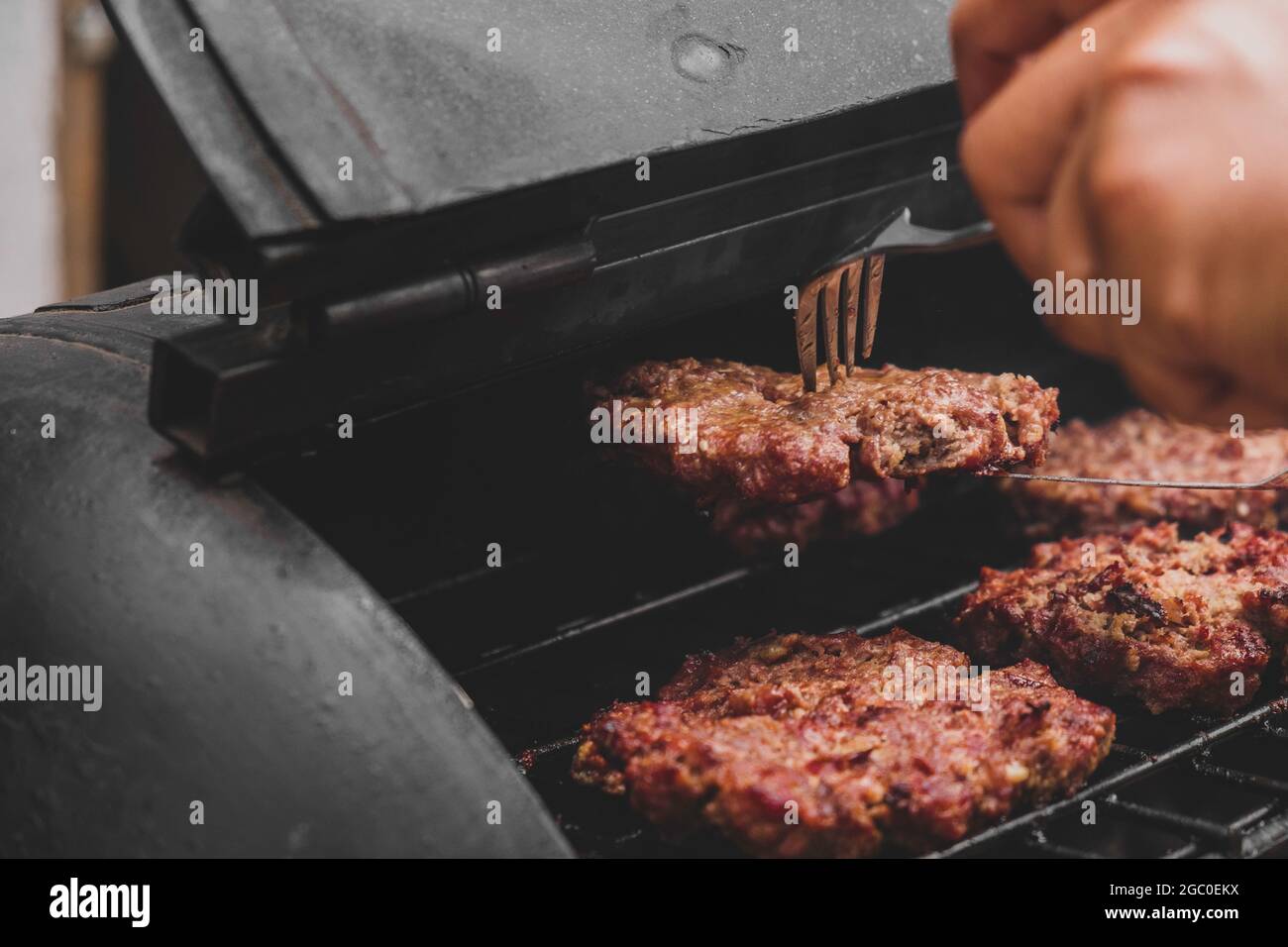 Hamburgers sur le gril avec le fromage gorm fondu sur la viande. Viande cuite sur le gril et charbon de bois. Chauffer sur la viande pour la cuisson. Viande grillée pour le bu Banque D'Images