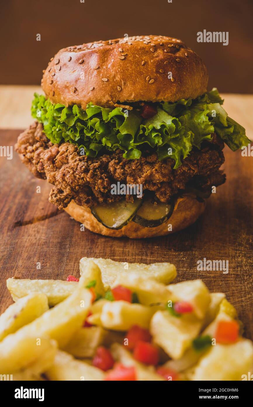 Hamburgers avec poulet frit et salade. Sandwich avec laitue, tomate, oignon, avocat, concombre et poulet. Hamburger à usage commercial avec salades vertes. Banque D'Images