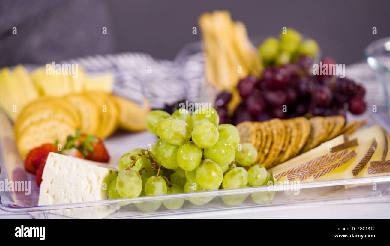 Étape par étape. Préparation d'une assiette de fromages avec des fruits  frais, du fromage gastronomique et des biscuits secs Photo Stock - Alamy
