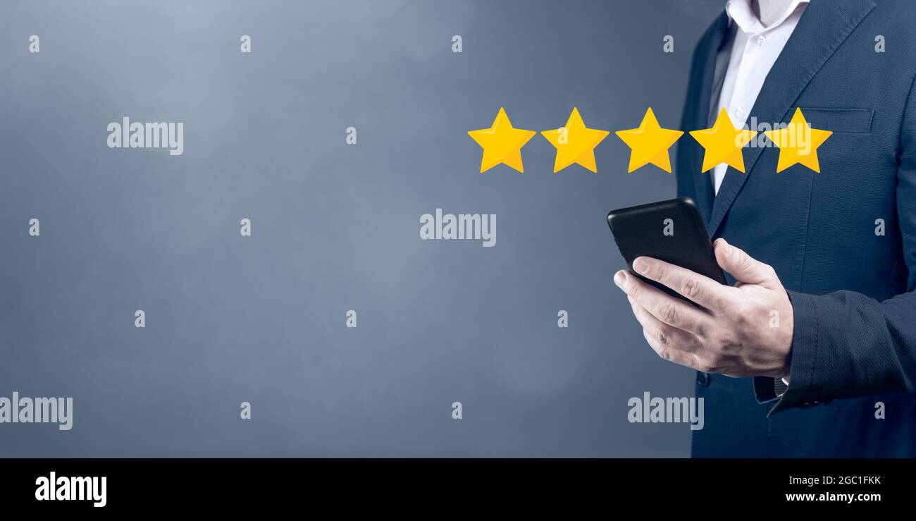 Note 5 étoiles 5 avec écran tactile pour homme d'affaires, concept sur les commentaires et les avis positifs des clients, excellentes performances. Homme d'affaires pointant Banque D'Images