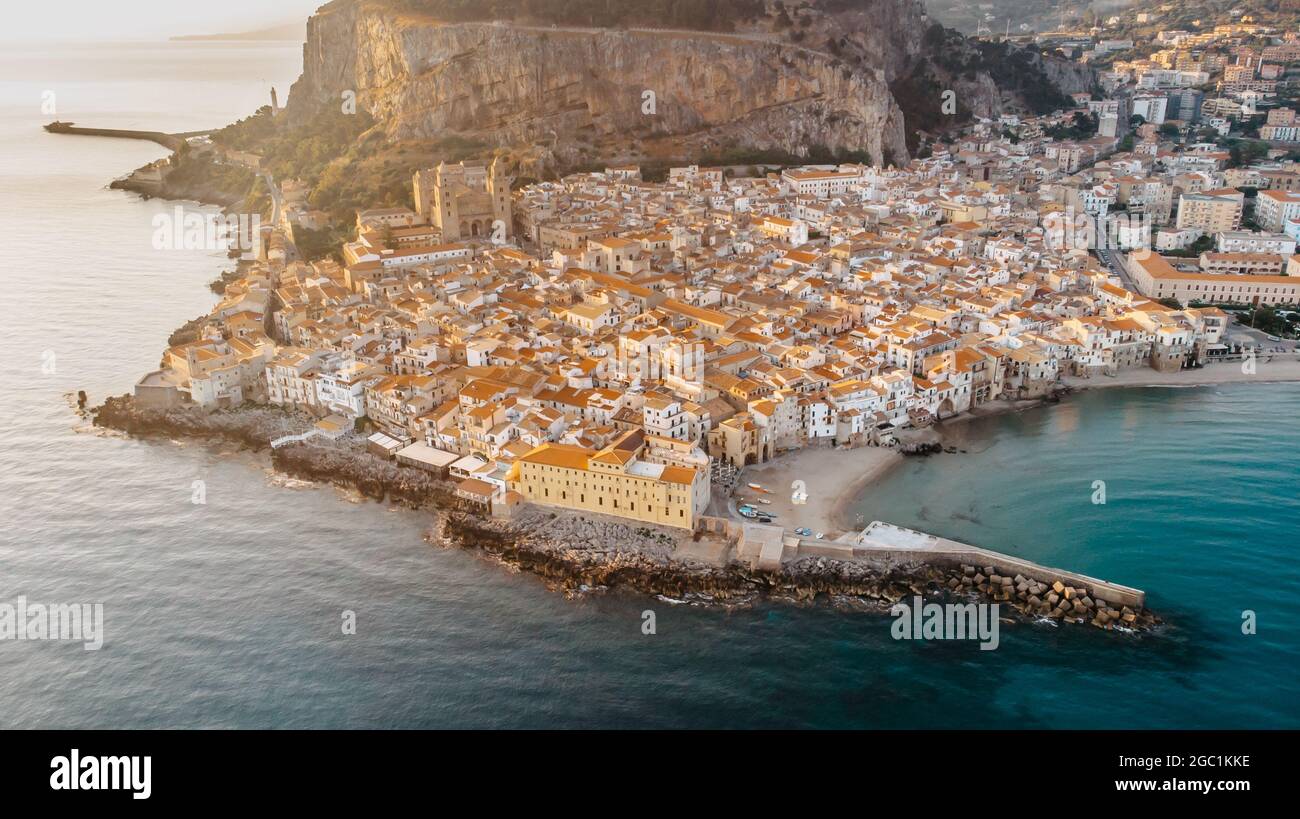 Lever de soleil sur le port de Cefalu, Sicile, Italie, vue panoramique aérienne de la vieille ville avec des maisons colorées en bord de mer, la mer et la falaise de la Rocca Banque D'Images