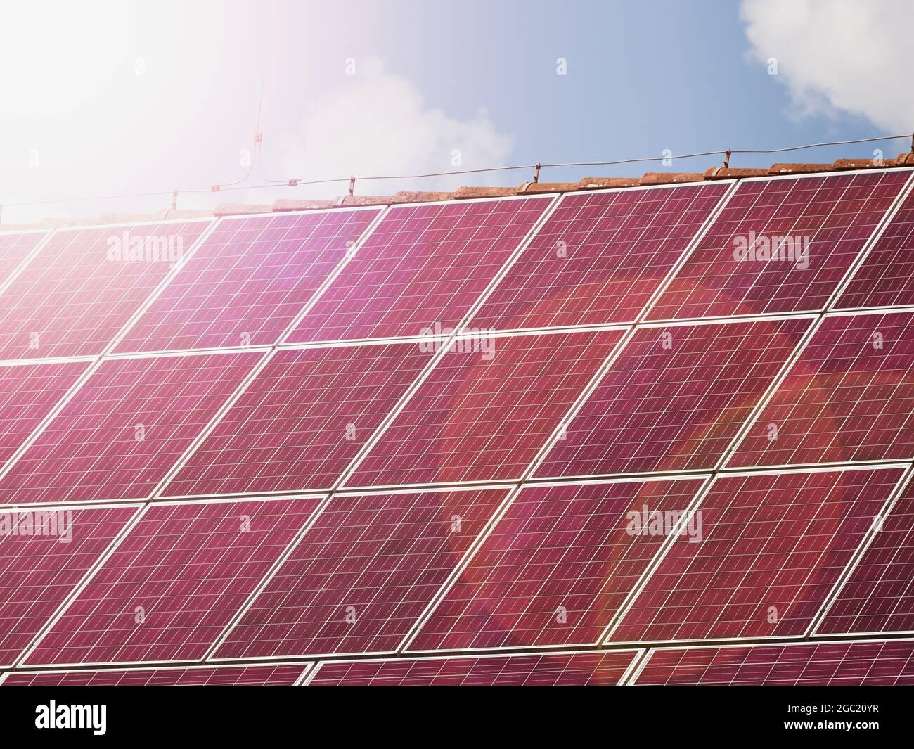 Panneaux solaires rouges sur le toit de la maison, concept d'énergie  renouvelable. Réflexion de soleil chaud dans la couverture de panneau  photovoltaïque Photo Stock - Alamy