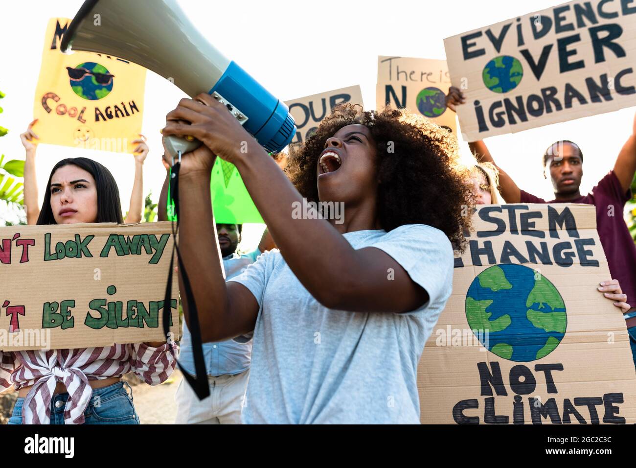 Groupe de militants protestant contre le changement climatique - des gens multiraciaux qui luttent sur la route brandissent des banderoles sur les catastrophes naturelles Banque D'Images