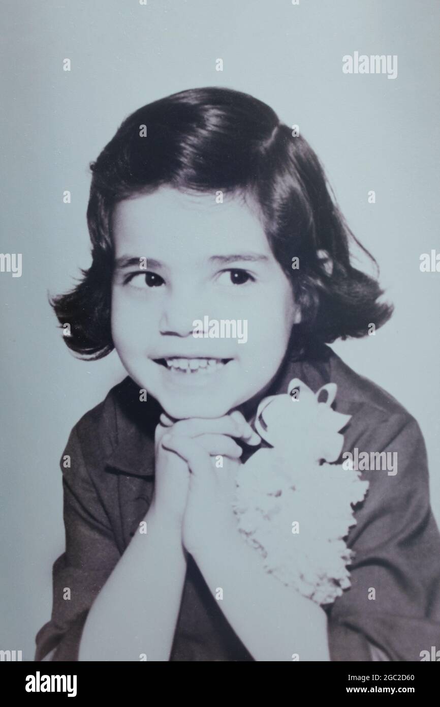 Une vieille photo d'une jolie fille souriant et posant pour l'appareil photo. Banque D'Images