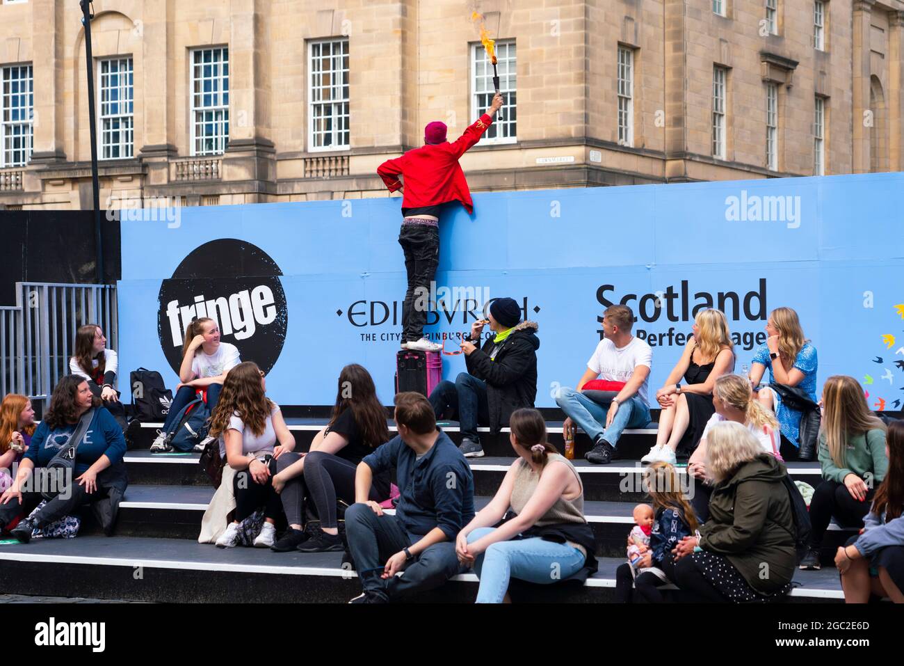 Édimbourg, Écosse, Royaume-Uni. 6 août 2021. Images du Royal Mile dans la vieille ville d'Édimbourg le jour de l'ouverture du Festival Fringe d'Édimbourg 2021. Le festival a l'air très différent d'il y a deux ans . Très peu d'espaces de représentation de rue sont autorisés et beaucoup moins de touristes sont évidents. De plus, une visibilité élevée de la police, il y a plus d'agents de police que d'interprètes dans la rue, est en contraste marqué avec les années précédentes. Pic; interprète de rue en panique essayant d'alerter le public de commencer son spectacle dans une zone protégée qui n'est pas évident pour les passants. Iain Masterton/Alamy Live News. Banque D'Images