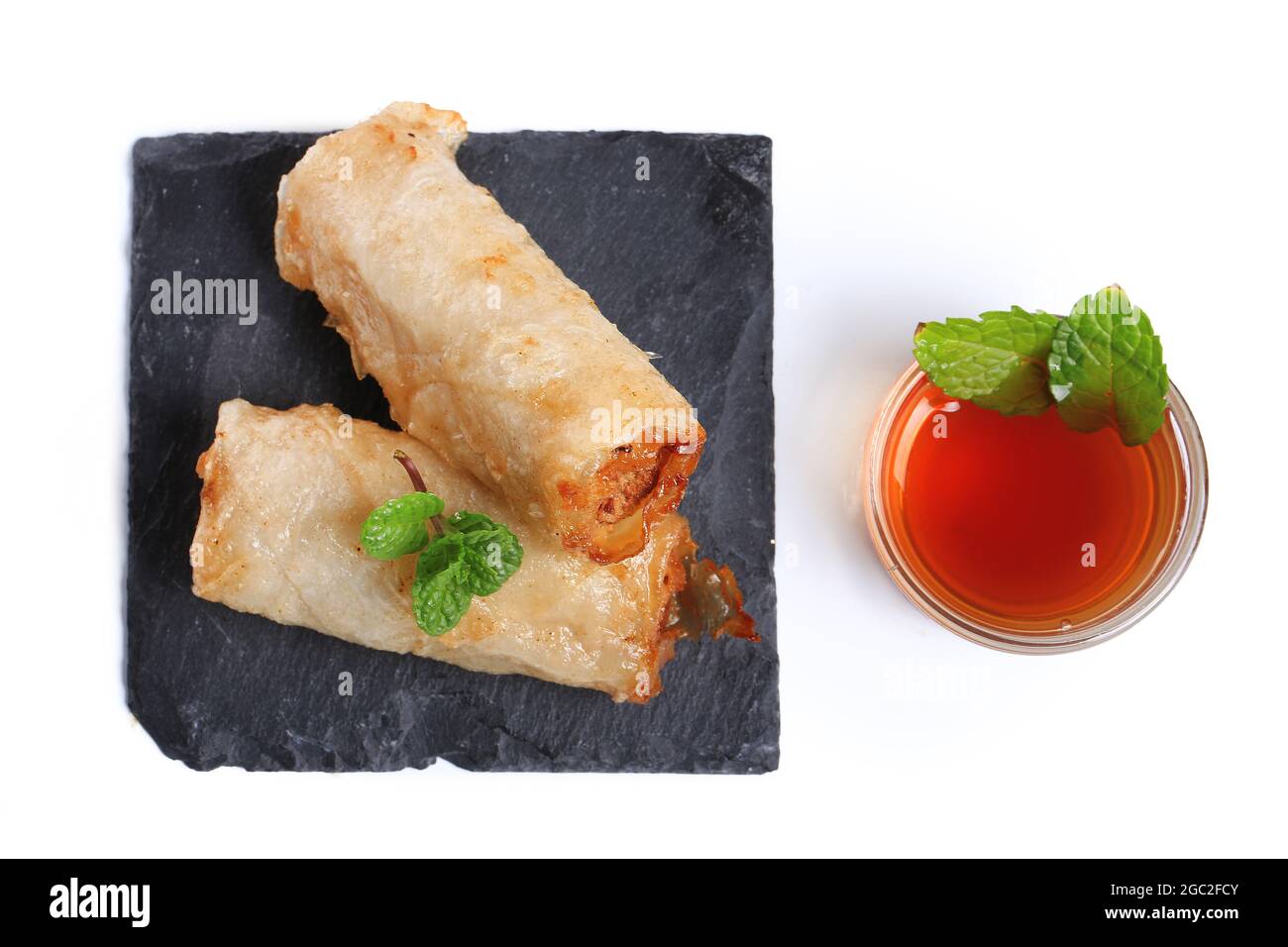 Roulés de printemps avec sauce nuoc mam et feuilles de menthe sur fond blanc Banque D'Images
