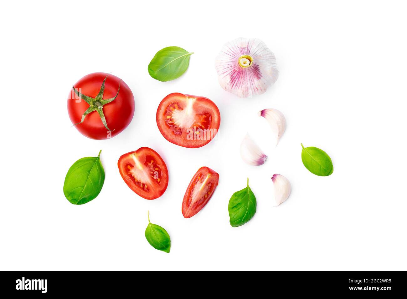 vue de dessus de ​​tomato entier et tranché avec feuilles de basilic et ail isolé sur fond blanc Banque D'Images