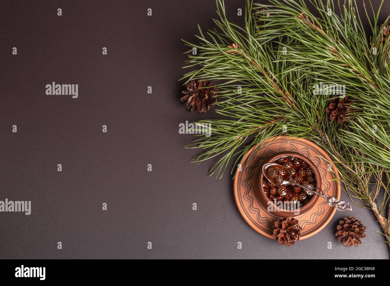 Confiture de pins doux. Dessert sibérien traditionnel, branches à feuilles persistantes fraîches. Arrière-plan en béton de pierre noire, vue de dessus Banque D'Images