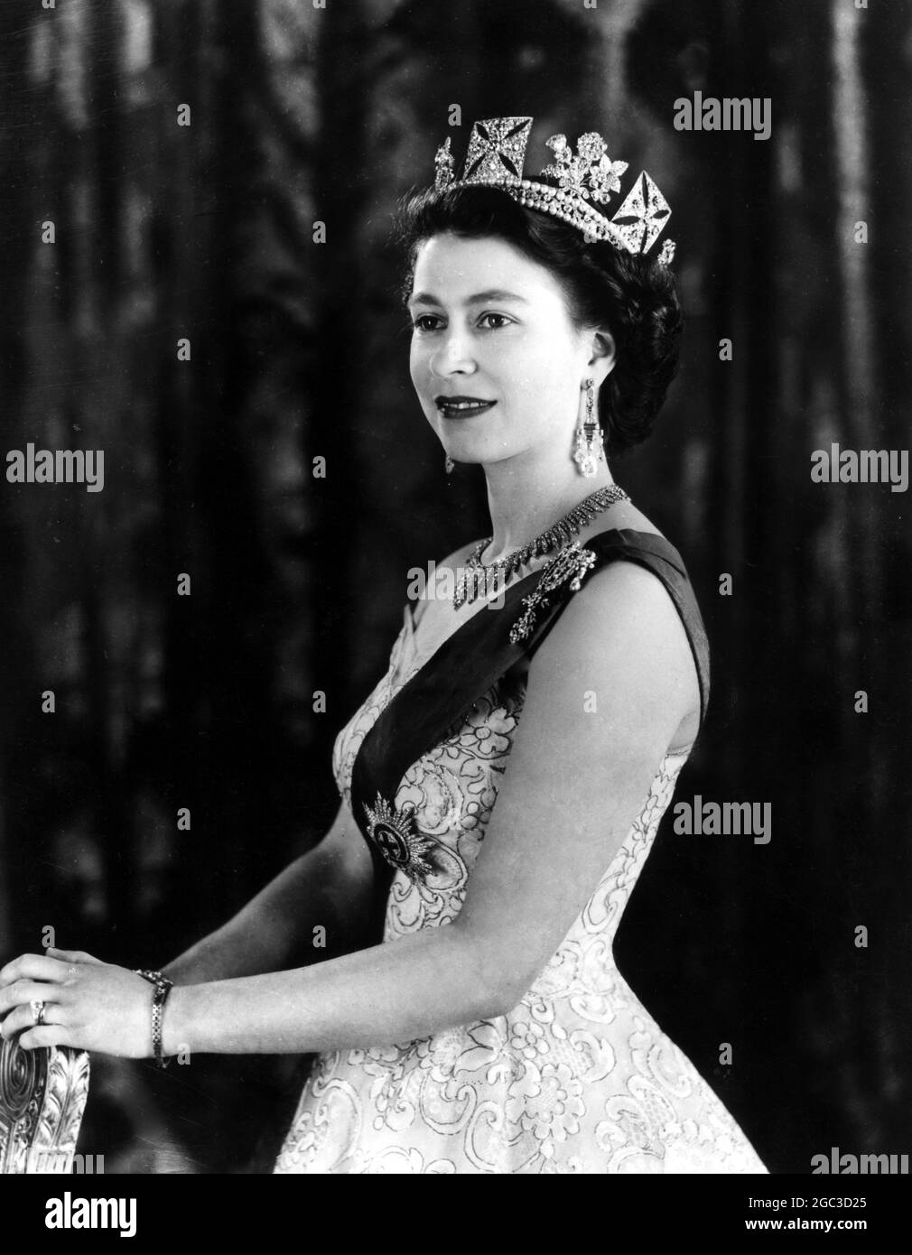 Un portrait de commandement royal chez Buck Queen Elizabeth II portant une robe de soirée avec le ruban bleu de Star of the Garter un collier de diamant (un cadeau de mariage de la ville de Londres) boucles d'oreilles en forme de goutte de diamant et deux bracelets de diamant. La broche en forme de losange au sommet du ruban bleu est une véritable mine familiale. Porter sur sa tête est un diamant diadem dont le bandeau est composé d'une rangée de diamants entre deux rangées de perles avril 1953 Banque D'Images