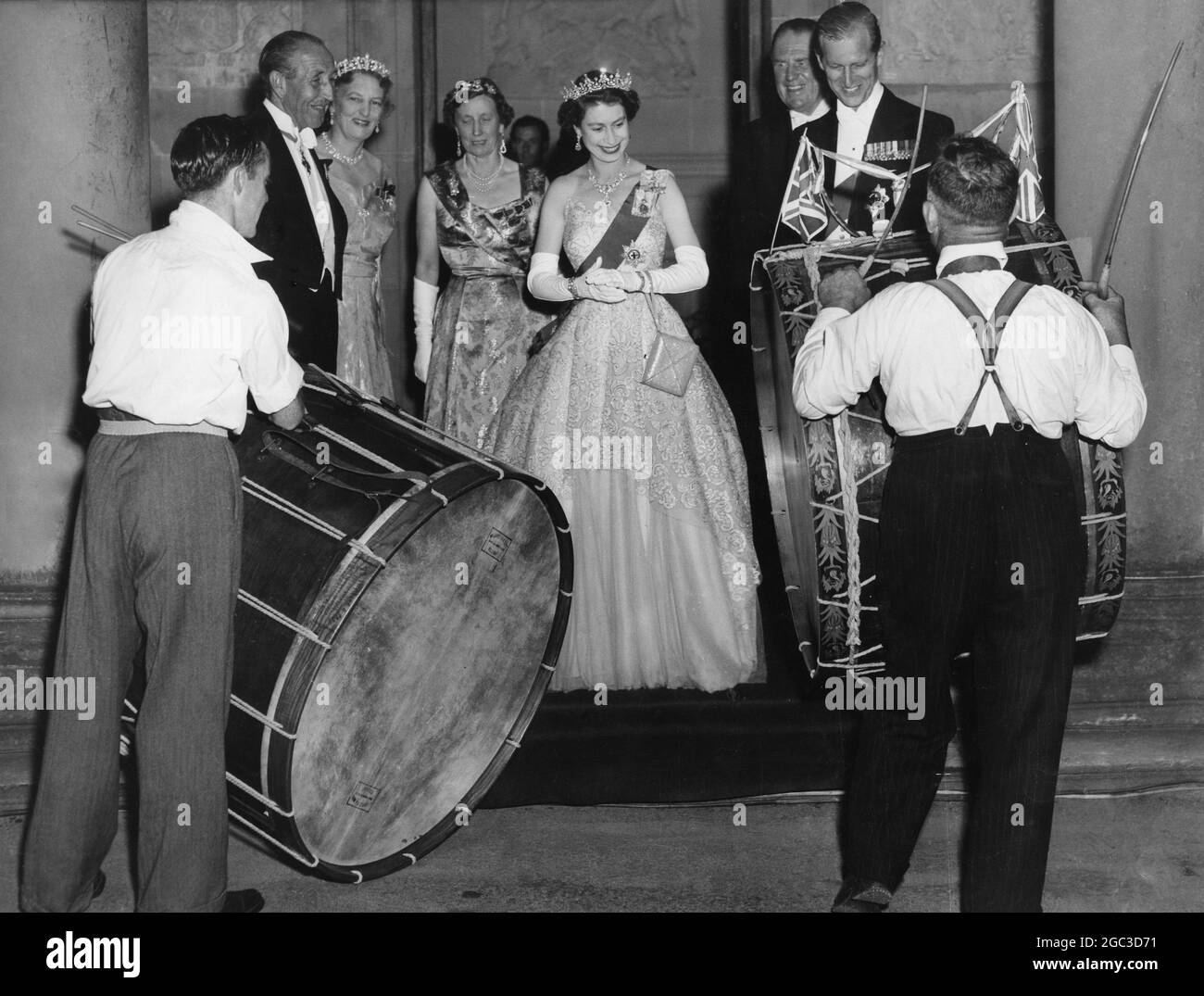 Hillsborough Northern Ireland Queen Elizabeth et le duc d'Édimbourg sourient en regardant des batteurs irlandais battre des tambours hors de la taille avec des cannes à l'extérieur de Government House debout par la reine de gauche à droite Viscount Brokeborough, Premier ministre d'Irlande du Nord Lady Wakehurst épouse du Gouverneur et Lady Brooke arrondissement 2 juillet 1953 Banque D'Images