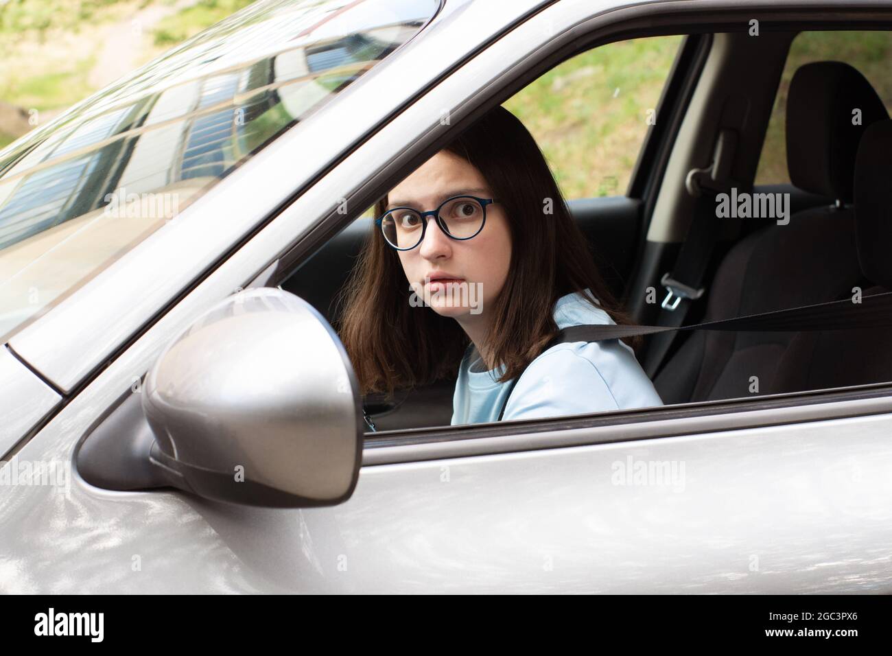 Gros plan d'un jeune conducteur de fille. Une fille apprend à conduire une voiture. Peur de la circulation, embouteillages. Stress lié à la conduite d'une voiture. Banque D'Images