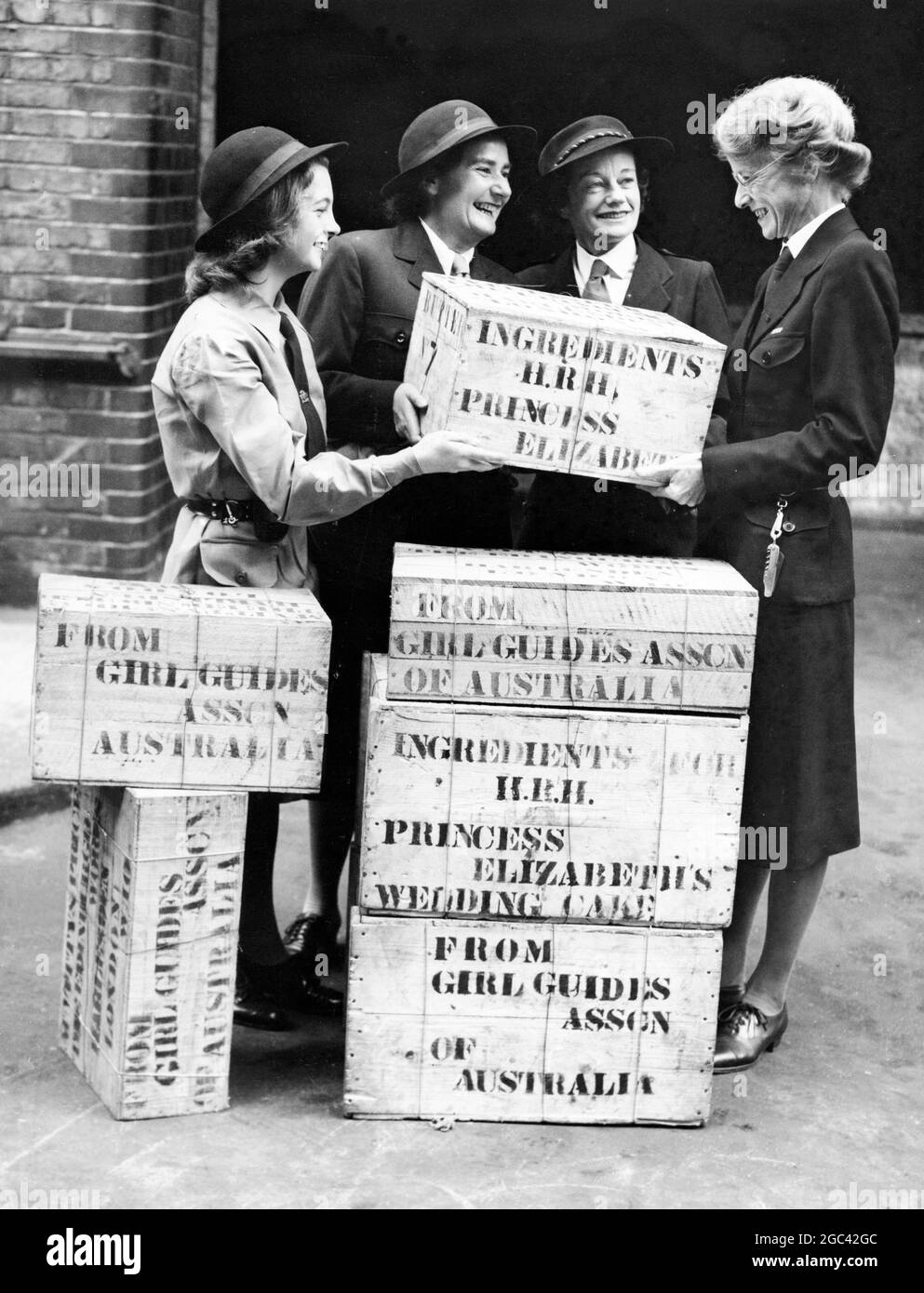 Cadeau des guides australiens pour le gâteau de mariage royal chaque guide australien a contribué quelque chose au gâteau de mariage de la princesse Elizabeth, qui est chef Ranger de l'Empire britannique. Séries photo : Mlle H. Anderton, Secrétaire générale du QG impérial, recevant le cadeau de la Ranger Monica Greenham d'Adélaïde, de la Commissaire aux guides Miss D Hayman de Melbourne et de la Commissaire aux guides Miss Gwen Stark de Bowral Guide HQ Londres, Angleterre - 17 septembre 1947 Banque D'Images