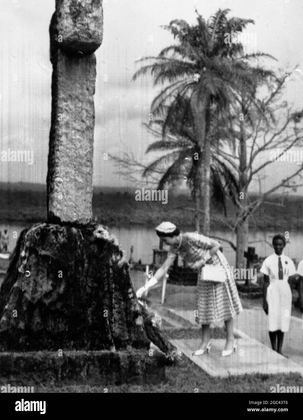 Calabar, Nigeria de l'est : la Reine place une couronne sous la pierre tombale de granit d'Aberdeen de 15 pieds de haut de Mary Slouor - une fille de moulin de Dundee qui a lutté contre la maladie, la pauvreté et l'ignorance en tant que missionnaire calabar pendant 37 ans. Mlle Slouor est décédée d'une maladie tropicale à l'âge de 67 ans. 9 février 1956 Banque D'Images