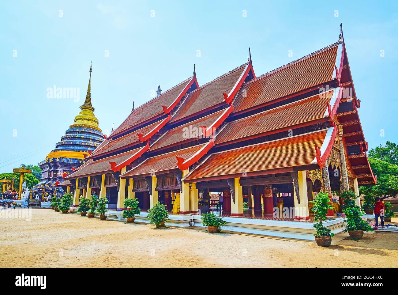 Le bâtiment de Viharn Luang avec des colonnes, le toit incliné et le Chedi de Wat Phra que Temple Lampang Luang en arrière-plan, Lampang, Thaïlande Banque D'Images