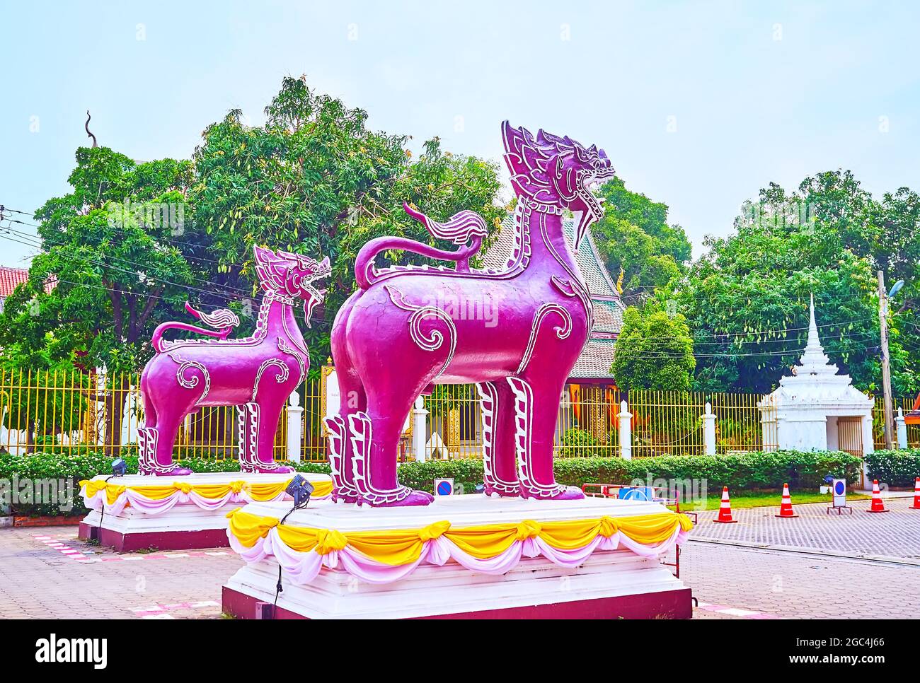 Le couple de lions de Singha violet vif garde l'entrée du monastère royal historique de Wat Phra que Hariphunchai Woramahawihan, Lamphun, Thaïlande Banque D'Images