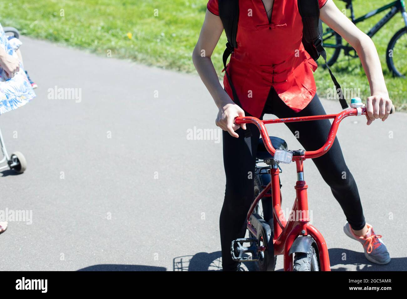 Une fille sur un petit vélo. Un cycliste. Marchez sur un transport à deux roues. Les pédales pour adolescents. Banque D'Images