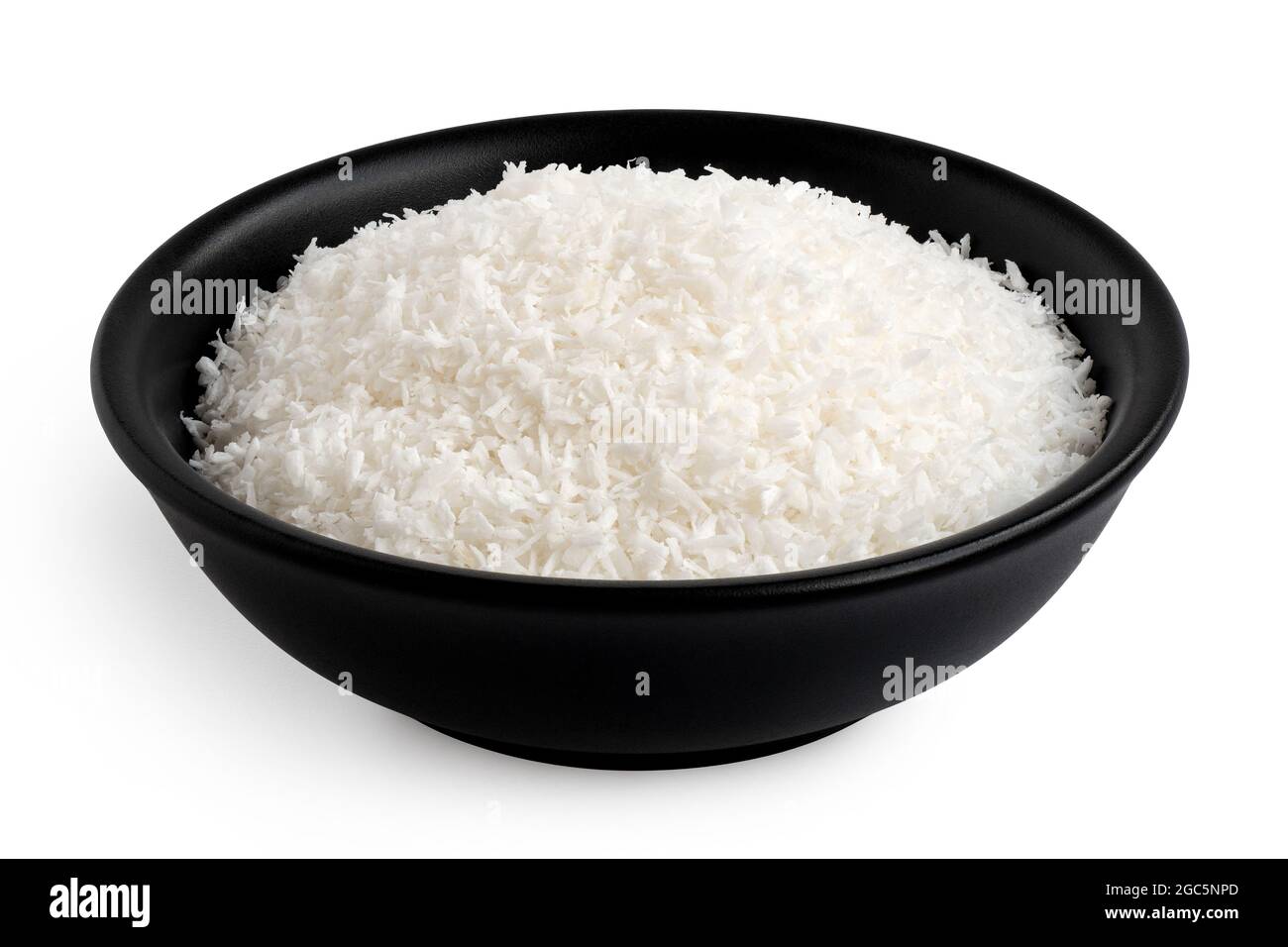 Noix de coco déshydratée dans un bol en céramique noire isolé sur blanc. Banque D'Images
