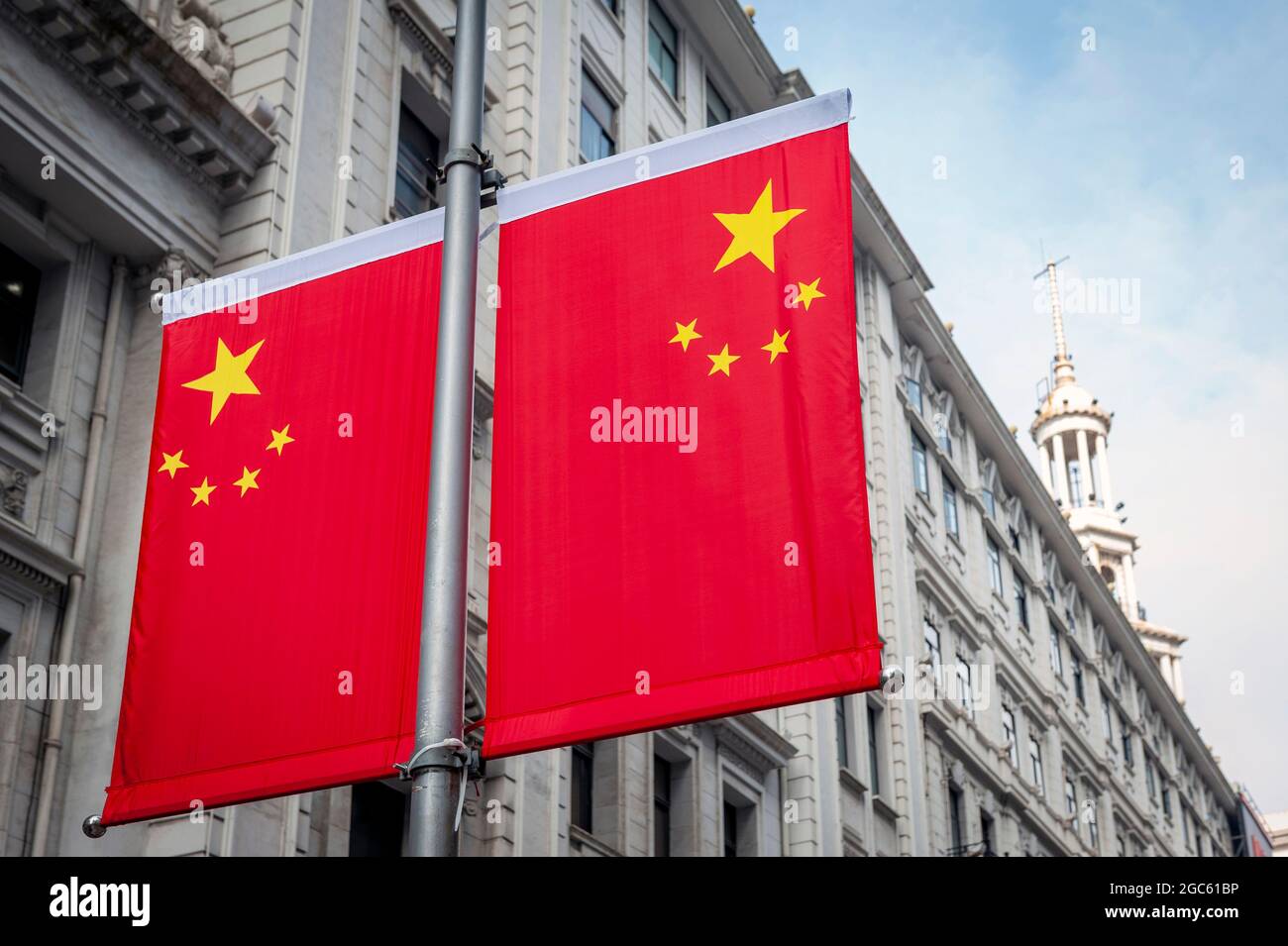 Drapeau national de la République populaire de Chine décoré devant un vieux bâtiment sur Nanjing Road dans le centre-ville de Shanghai Banque D'Images
