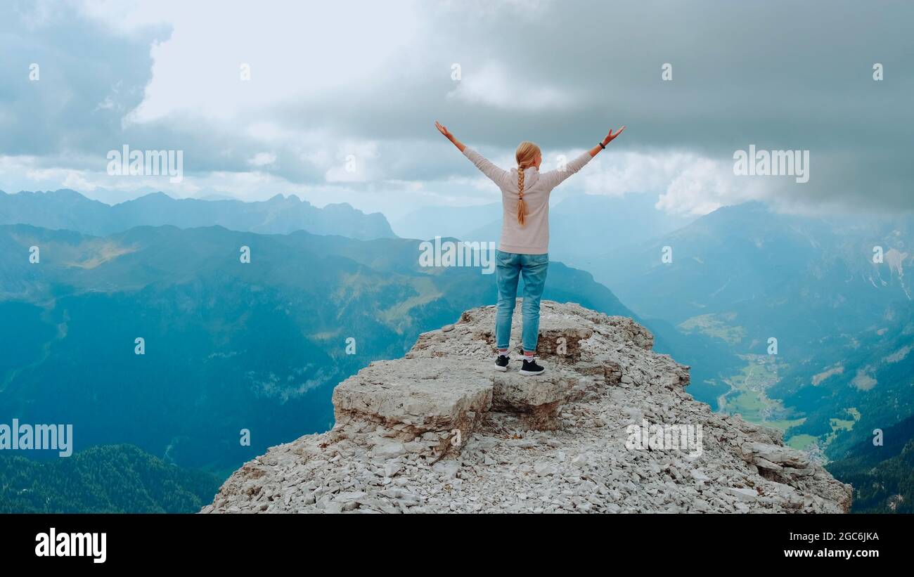 Jeune femme aux bras étirés appréciant la beauté de la nature sur le rocher de montagne. Vue fantastique sur le paysage. Banque D'Images