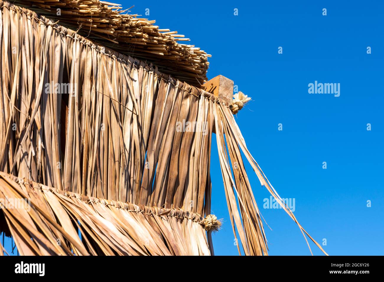 Parasols en paille sur la plage de Puta Zeza à Athènes en Grèce Banque D'Images